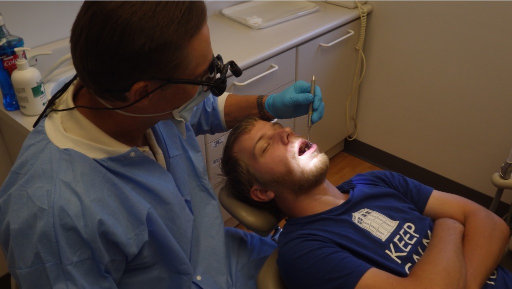 A dentist from the Chicago Dental Society Foundation tending to Hesed House guest, Robert Johnson.